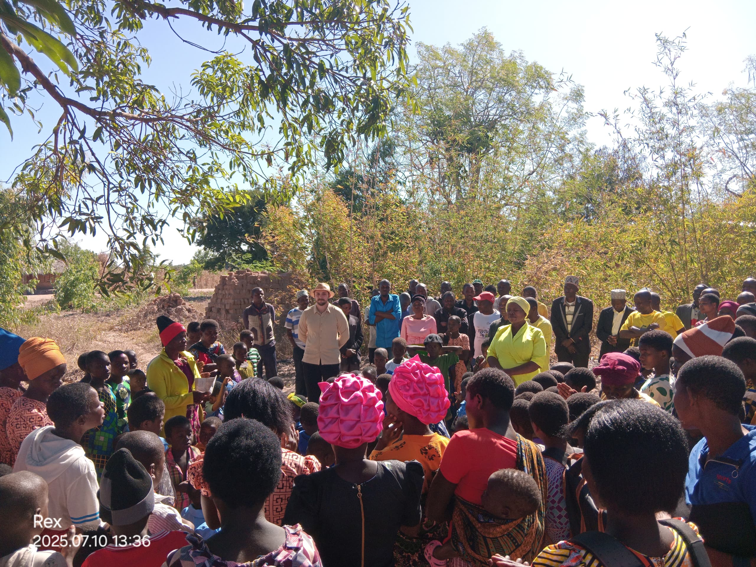 Malawians have gathered in an open-air space for a DTH session.