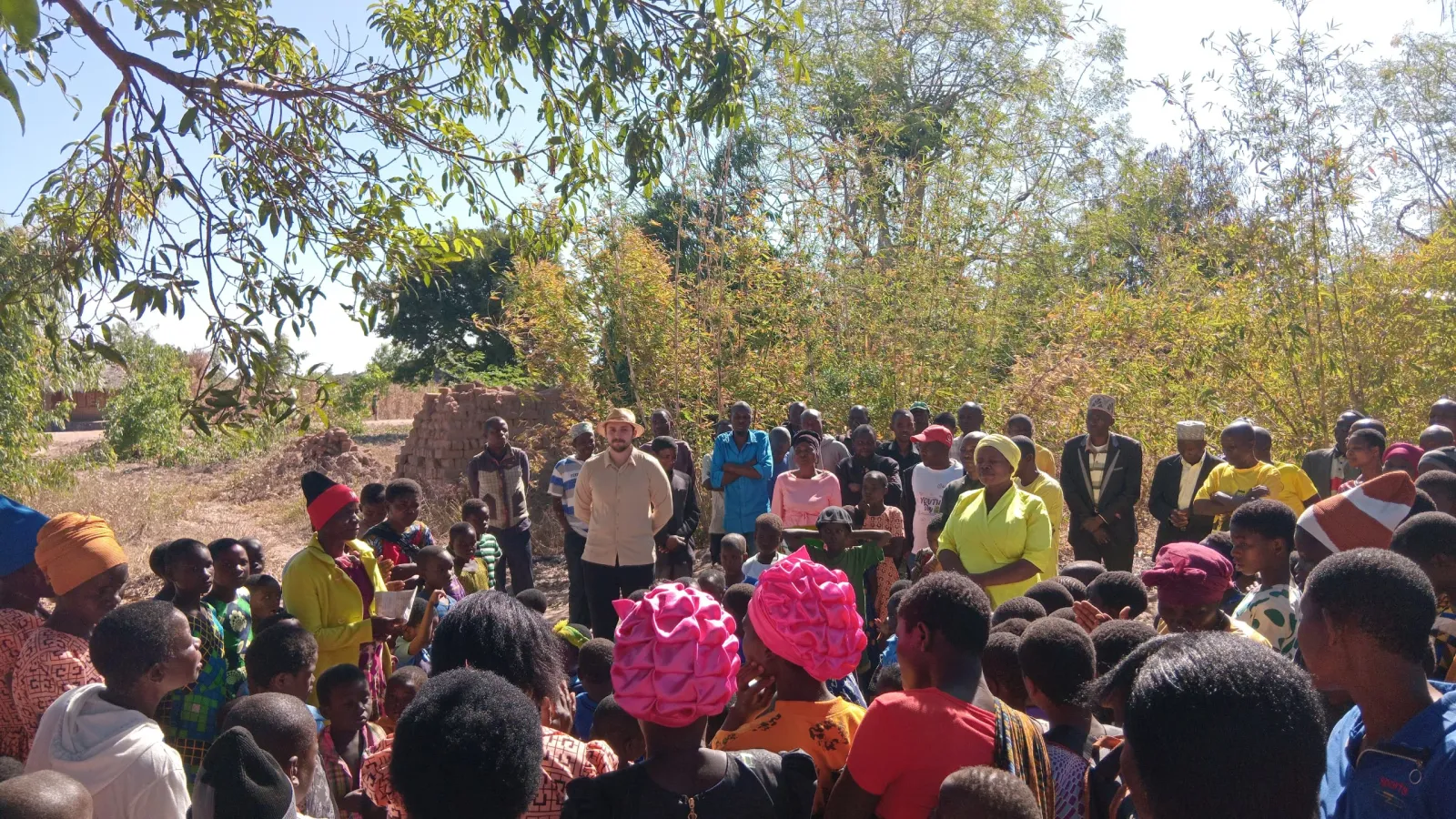 Malawians have gathered in an open-air space for a DTH session.